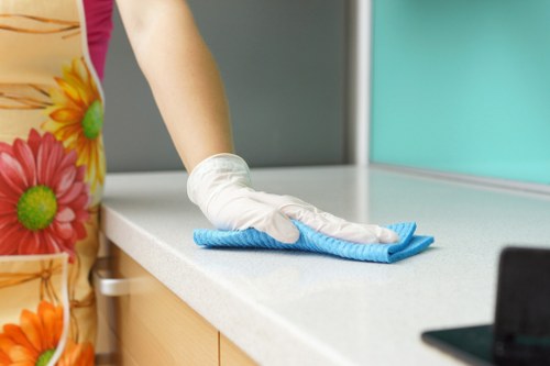 Team member wearing PPE while cleaning a surface safely